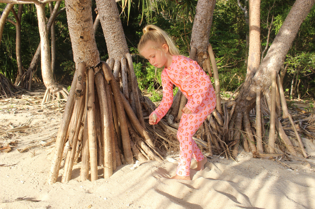 Girl in pink stinger suit on the beach in the whitsundays